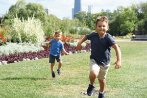 two young boys running in a park