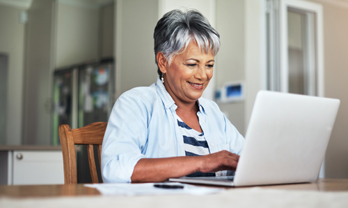 An older woman on her laptop logging into ACES$ Online