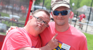 man with developmental disability hugging another man