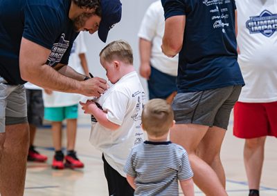 a boy getting his shirt signed by a Penn State Football player