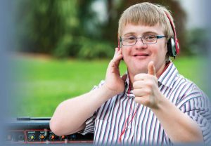 a young man with developmental disability giving a thumbs up