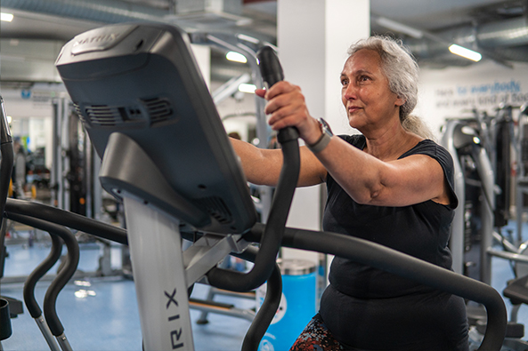 older woman using a treadmill in a gym